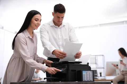 Employees using new modern printer in office Stock Photos