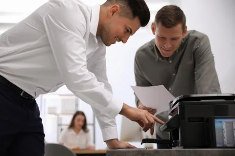 Employees using new modern printer in office Stock Photos