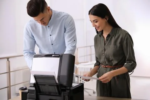 Employees using new modern printer in office Stock Photos