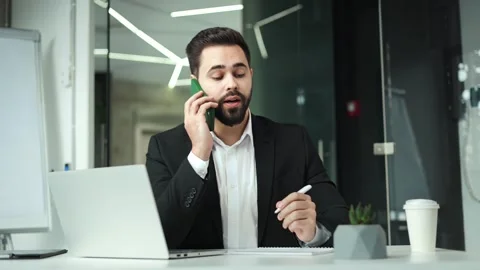Employer making notes while having phone call and sitting in contemporary office Stock-Footage 258545091