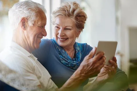 Empowered to connect to the things that matter. a happy senior couple using a Stock Photos