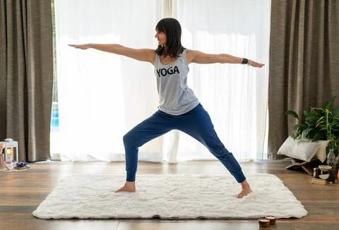 Empowered yoga instructor showcasing the powerful Warrior II pose Stock Photos