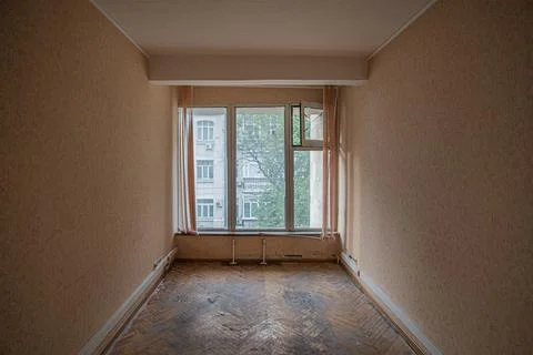 Empty abandoned room with a large window in the city. Stock Photos