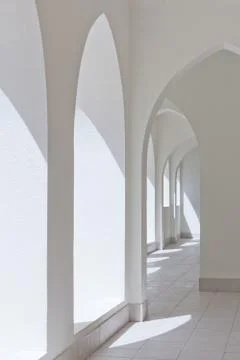 Empty abstract light interior corridor background with arches and sunlight Stock Photos