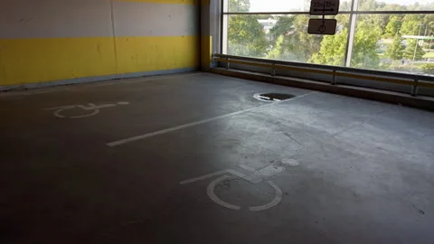Empty accessible parking space inside sunlit garage with concrete floor, window Stock Footage 345455686