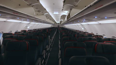 Empty Airplane Cabin Interior with Rows of Dark Seats and Red Accents. Stock Footage 338360628