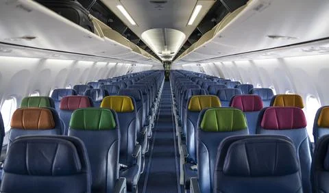 Empty Airplane inside cabin view with colorful seats - travel theme Stock Photos