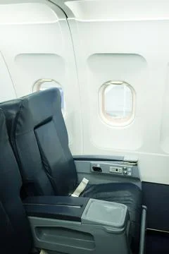 Empty airplane seat by the window with a view of the aircraft interior and .. Stock Photos