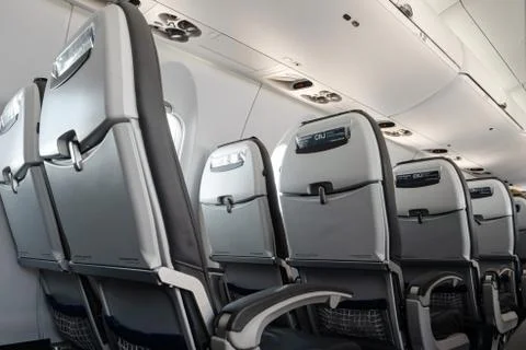 Empty airplane seats in second class on an international flight during August Stock Photos