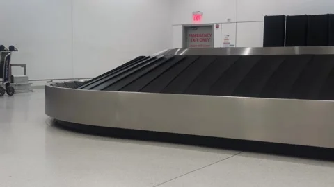 Empty airport baggage claim carousel rotating inside a baggage claim area Stock Footage 338188317