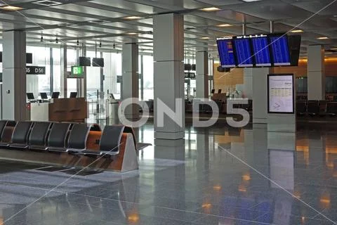 Empty airport departure lounge waiting area with flight information board scr Stock Photos