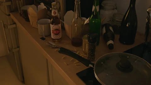 Empty Alcohol Bottles on Messy Kitchen Counter Depicting Alcoholism Stock Footage 344872815