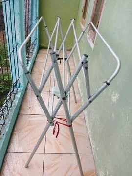 Empty Aluminum Folding Clothes Drying Rack on a Tiled Balcony 写真素材