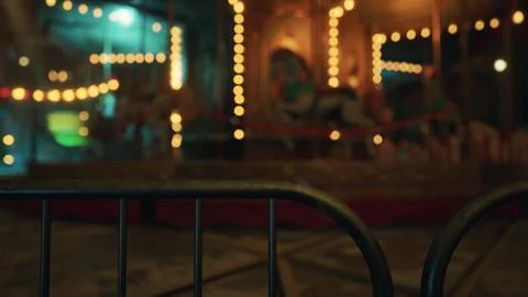 An empty amusement park features a deserted carousel at night with lights on Ilustração Stock