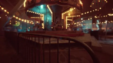 Empty amusement park at night with glowing lights and deserted rides Ilustração Stock