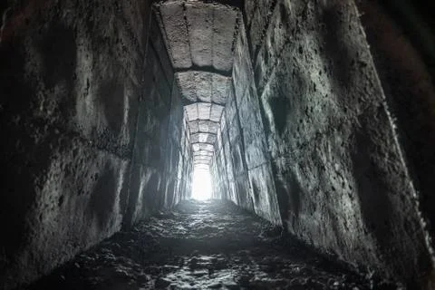 Empty ancient square tunnel with light in the end. Stock Photos