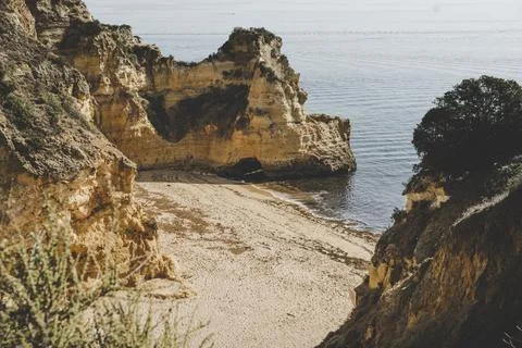 Empty and abandoned beach surrounded by cliffs on the coast of Algarve near L Stock Photos