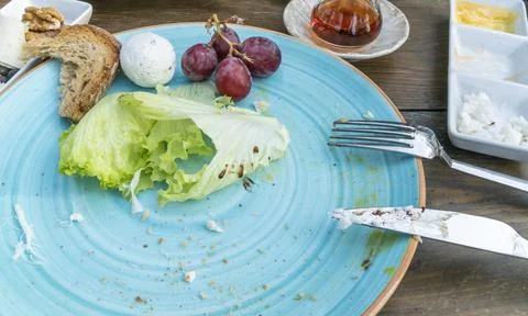 Empty and dirty plate of breakfast leftovers on table. Stock Photos