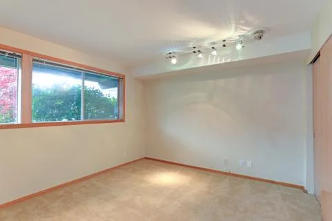 Empty apartment interior features white walls and beige carpet floor. Stock Photos