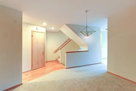 Empty apartment interior features white walls and beige carpet floor. Stock Photos