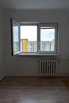 Empty apartment room with open white window and radiator Stock Photos