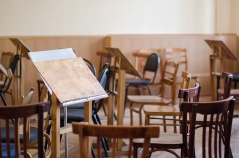 Empty art class audience with worn chairs and easels, artist's studio Stock Photos