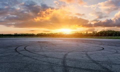Empty asphalt race track road and green forest with sky clouds Stock Photos