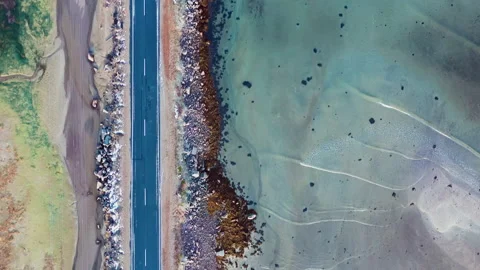 Empty asphalt road along the coast. Perpendicular aerial drone cinematic shot. Stock Footage 145478601