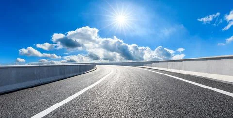 Empty asphalt road and blue sky with white clouds. Stock Photos