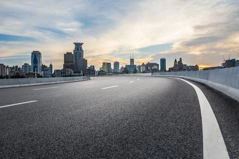 Empty asphalt road and city skyline with modern commercial buildings. Stock Photos