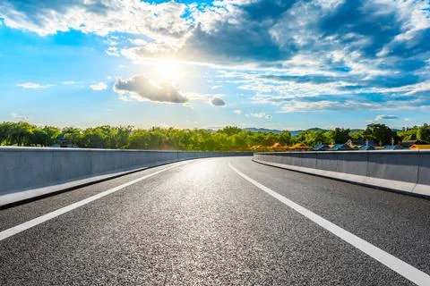 Empty asphalt road and mountain with forest landscape at sunset. Stock Photos