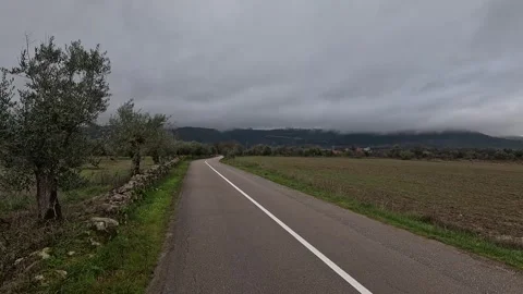 An empty asphalt road curves through rural fields Stock Footage 346291986