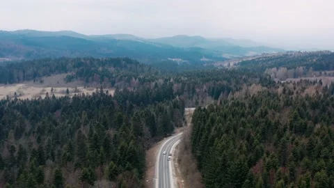 Empty asphalt road over mountains and forests, aerial view. Beautiful landscape Stock Footage 181576924