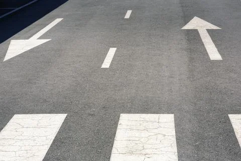 Empty Asphalt Road Surface Features Weathered White Directional Arrows in Stock Photos