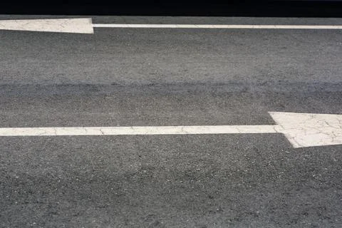 Empty Asphalt Road Surface Features Weathered White Directional Arrows in Stock Photos