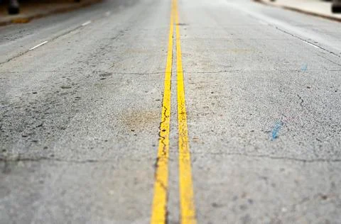 Empty asphalt road with two continuous yellow lines painted on the surface. Stockfoto's