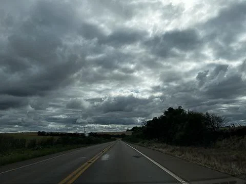 Empty asphalt road under dramatic cloudy sky in rural landscape of Rio Gran.. Stock Photos