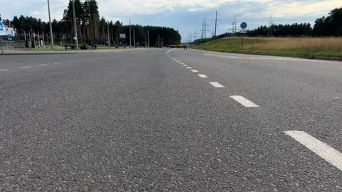 Empty asphalt road with white dashed markings running through a forest area Stock Footage 341510385
