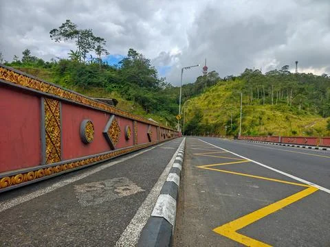 Empty asphalt road winding through mountain hills Stock Photos