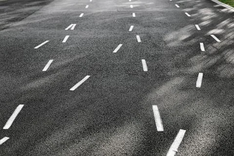 Empty asphalt running track with white dashed lines and shadows. Concept of.. Stock Photos