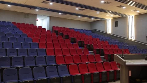 Empty Auditorium Theater with Blue and Red Seating Rows and Wooden Podium for Stock Footage 334492533