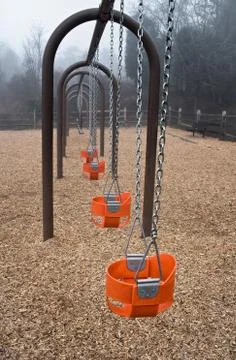 Empty baby swings Stock Photos