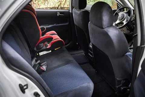 Empty back seat of a compact car with child seat Stock Photos