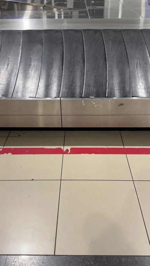An empty baggage carousel conveyor belt rotates slowly in an airport, waiting Stock Footage 302468742
