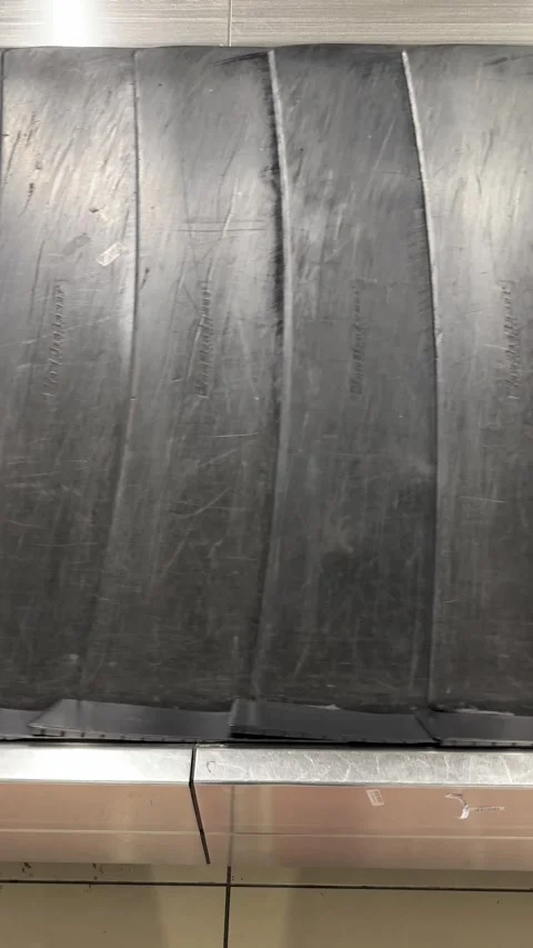 An empty baggage carousel conveyor belt rotates slowly in an airport, waiting Video stock 303357788