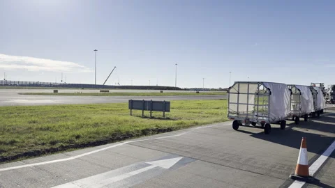 Empty baggage carts parked at airport panning Видео 333640527