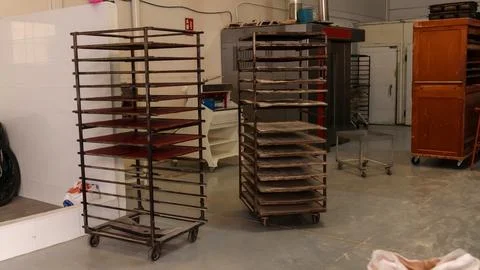 Empty bakery racks in an industrial baking facility Stock Photos