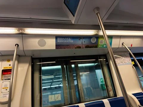 Empty Barcelona metro interior with platform screen doors, poles and advert.. Stock Photos