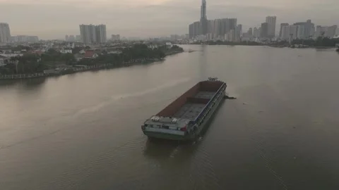 An empty barge slowly floats down the Saigon River Stock Footage 296592723