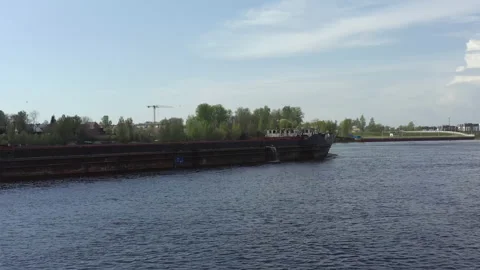 An empty barge for transporting timber or sand floats on the river. Cargo ship Video stock 155184899